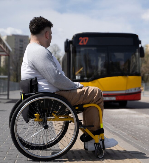 Person in wheelchair waiting for bus with NDIS Transport Services.