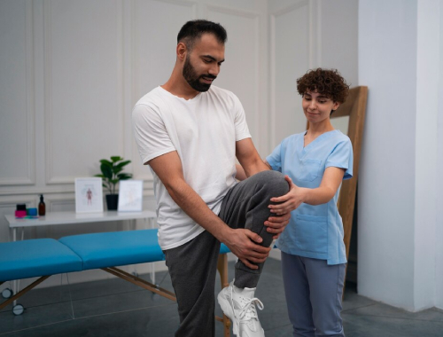 Physiotherapy assisting patient with knee exercise at Physiotherapy clinic.