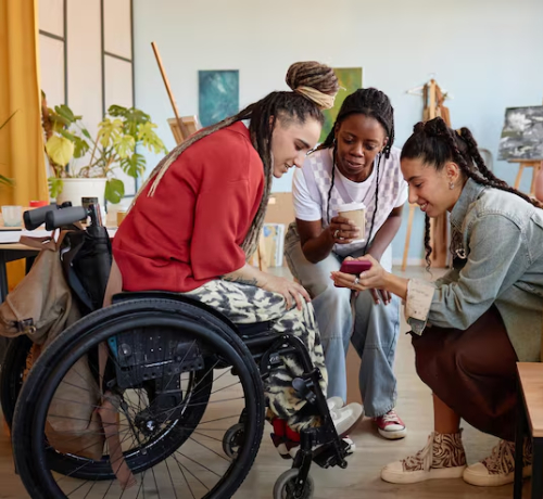 NDIS Household Tasks support workers assisting wheelchair user at home.