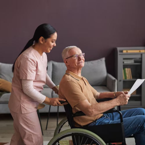 NDIS In-Home Support nurse helping an elderly man in a wheelchair at home, delivering compassionate In Home Care Support for aged care and daily living assistance.
